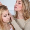 mamma controlla i capelli della figlia per vedere se ha i pidocchi
